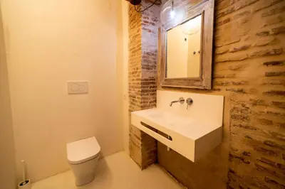 a bathroom with a sink and a toilet and a mirror at Design house with swimming pool near the sea in Valencia