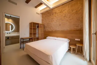 a bedroom with a white bed and a wooden wall at Design house with swimming pool near the sea in Valencia