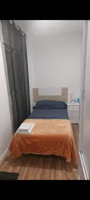 a bedroom with a bed with a orange blanket at Lyesblb in Valencia