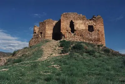 an old castle on top of a grassy hill at Apartamentos Rurales San Juan in Castellnovo
