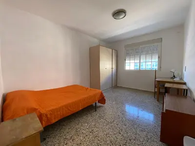 a bedroom with an orange bed and a window at BIGGER FLAT IDEAL PARA FAMILIA NEAR CENTER AND BEACH in Valencia