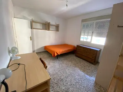 a small bedroom with an orange bed and a desk at BIGGER FLAT IDEAL PARA FAMILIA NEAR CENTER AND BEACH in Valencia