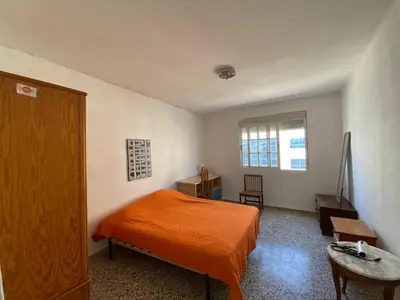 a bedroom with an orange bed and a table at BIGGER FLAT IDEAL PARA FAMILIA NEAR CENTER AND BEACH in Valencia