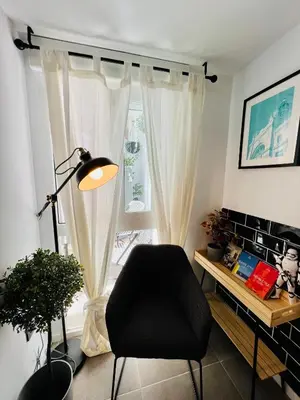 a living room with a chair and a window at COOL LOFTS ALAMEDA VALENCIA in Valencia