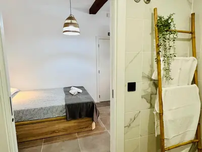 a small bedroom with a bed and a shower at COOL LOFTS ALAMEDA VALENCIA in Valencia
