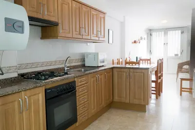 a kitchen with wooden cabinets and a stove top oven at El Maestro in Caudiel