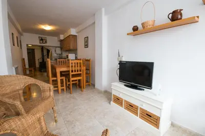 a living room with a television and a dining room at El Maestro in Caudiel