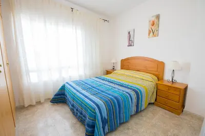 a bedroom with a bed and a dresser and a window at El Maestro in Caudiel