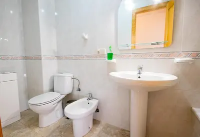 a white bathroom with a toilet and a sink at El Maestro in Caudiel