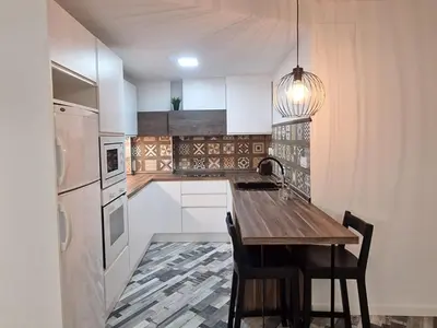 a kitchen with a wooden table and a refrigerator at Selena Beach in Cullera