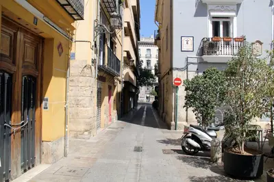 a narrow alley with a scooter parked on a street at City Centre Room in Valencia