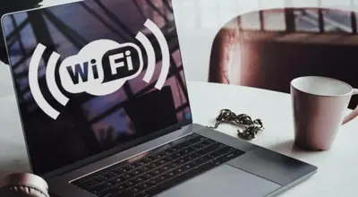 a laptop computer sitting on top of a table with a cup at UIM Mediterraneo PB Luis Vives Wifi in Puerto de Sagunto