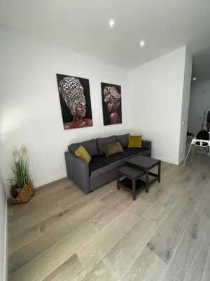 a living room with a couch and paintings on the wall at UIM Mediterraneo PB Luis Vives Wifi in Puerto de Sagunto