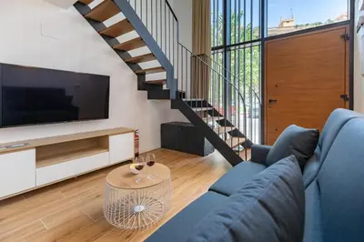 a living room with a blue couch and a tv at Travel Habitat Alameda Suites. in Valencia