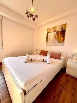 a bedroom with a large white bed in a room at Apartamento Guimerà in Valencia