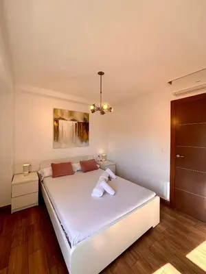 a room with two white beds with candles on them at Apartamento Guimerà in Valencia