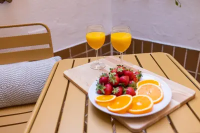 a plate of fruit and two glasses of orange juice at FLORIT FLATS - The Apolo Suite in Valencia