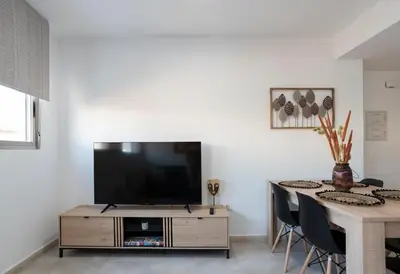 a living room with a tv and a table at Nuevo y moderno apartamento con aire acondicionado - El Cid 4 in Burriana