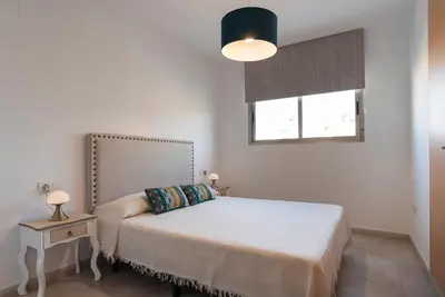 a white bedroom with a bed and a window at Nuevo y moderno apartamento con aire acondicionado - El Cid 4 in Burriana