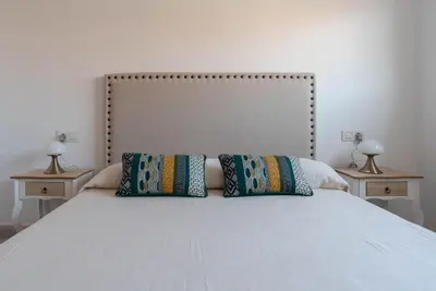a white bed with two pillows on top of it at Nuevo y moderno apartamento con aire acondicionado - El Cid 4 in Burriana