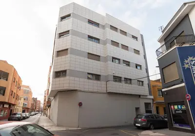 a tall white building on the side of a street at Nuevo y moderno apartamento con aire acondicionado - El Cid 4 in Burriana