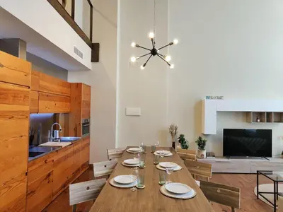 a dining room with a long table and a kitchen at The Luxury Apartment in Valencia