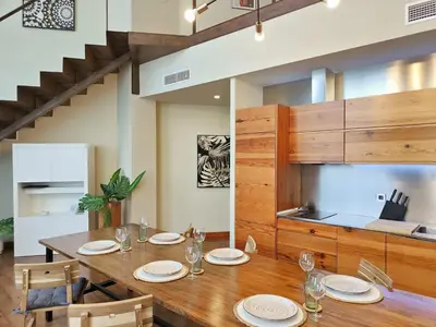 a dining room with a table and a kitchen at The Luxury Apartment in Valencia