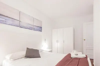 a white bedroom with a bed and a painting on the wall at Apartamento Centro Histórico Valencia de 2 habitaciones in Valencia