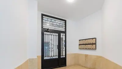 a black door in a white room with stairs at Apartamento Centro Histórico Valencia de 2 habitaciones in Valencia