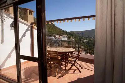 a table and chairs on a balcony with a view at Ático El Más allá in Chulilla