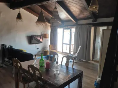 a dining table and chairs in a living room at Ático El Más allá in Chulilla
