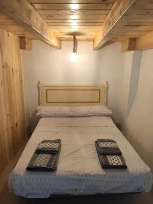 a bed in a room with two remote controls on it at Ático El Más allá in Chulilla