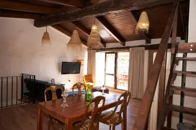 a dining room with a wooden table and chairs at Ático El Más allá in Chulilla