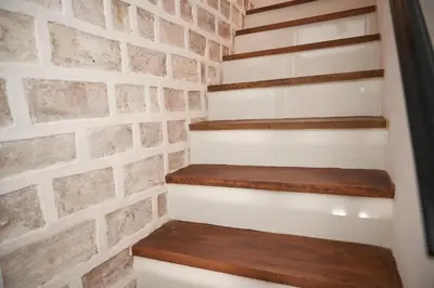 a brick wall with wooden stairs in a room at Ático El Más allá in Chulilla
