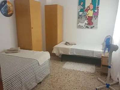 a bedroom with two beds and a painting on the wall at La Chirrichana 2 in Bicorp