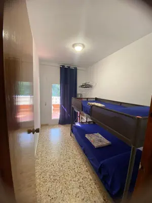 a room with a bunk bed and a door with a window at La Chirrichana 2 in Bicorp