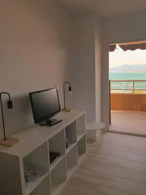 a living room with a desk with a television on it at Cullera - Florazar II con piscina, tenis y club social in Cullera