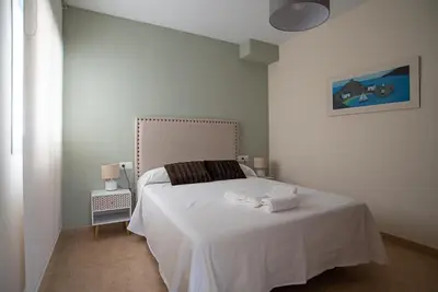 a white bedroom with a bed with a white blanket at Nuevo apartamento en playa con aire acondicionado MASBO 3 in Moncófar