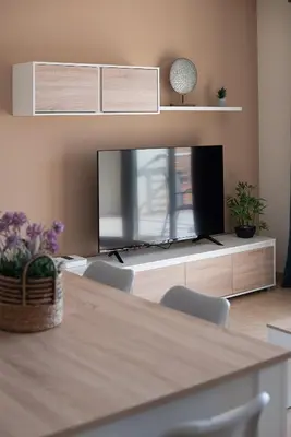 a living room with a tv and a table and chairs at Nuevo apartamento en playa con aire acondicionado MASBO 3 in Moncófar