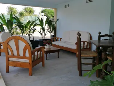a living room with a couch and chairs and plants at Villa Isabelle in Barraca de Aguas Vivas
