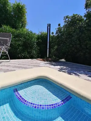 a swimming pool with a table and a chair next to it at Villa Isabelle in Barraca de Aguas Vivas