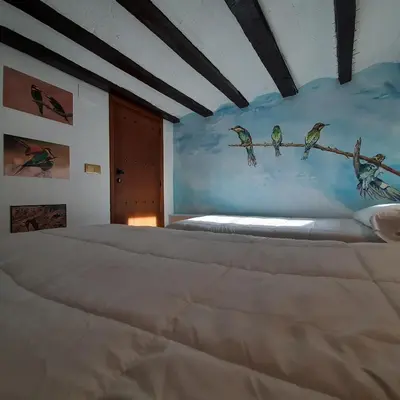 a bedroom with a bed with birds on the wall at Casa rural rústica 
