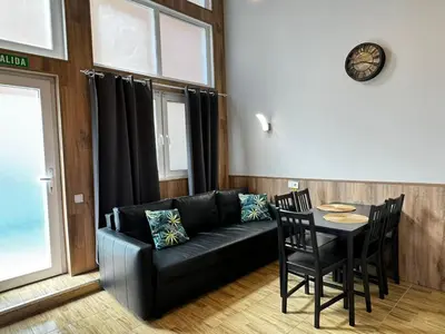 a living room with a black couch and a table at Lliri 32 in Valencia