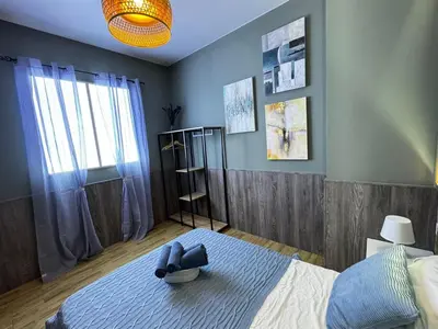 a bedroom with a bed with a blue wall at Salom 5 in Valencia