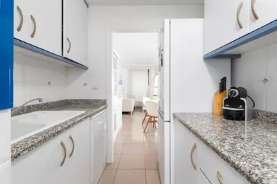 a kitchen with white cabinets and granite counter tops at Patacona Breeze in Valencia