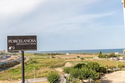 a sign for a road with the ocean in the background at Patacona Breeze in Valencia