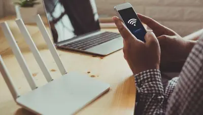 a person holding a cell phone in front of a laptop at UIM Mediterraneo FELIPE 8 WIFI in Puerto de Sagunto