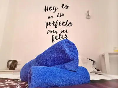 a pile of blue pillows on a bed at Relax Les Palmeres in Sueca