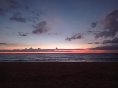 a sunset on a beach with the ocean at Relax Les Palmeres in Sueca