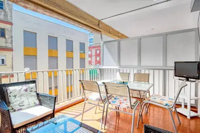 a balcony with a table and chairs and a television at Relax Les Palmeres in Sueca